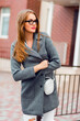 © Svetlana Sokolova - Fashion image of stylish blond woman in grey coat walking on the street.