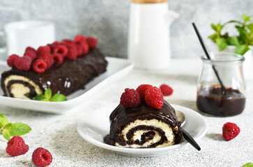 Wall Mural - Biscuit roll with chocolate and raspberries on a light concrete background.