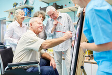 Group Of Seniors With Dementia Paints Together