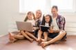 © Angelov - Animated family buying online lying down on bed at home