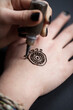 © Alberto Bogo/Stocksy - Woman drawing a henna tattoo on a hand