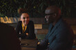 © Jacob Lund/Stocksy - Happy young woman with her office colleagues sitting at cafe