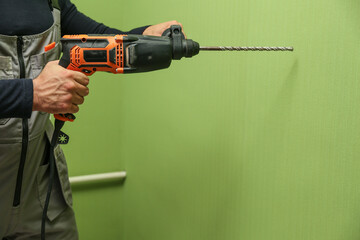 Wall Mural - man's hand holds hammer drill