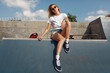 © puhhha - Summer. Skater Girl Sitting On Concrete Skate Ramp At Skatepark. Female Teenager In Casual Outfit With Skateboard. Urban Sport As Lifestyle For Active Teens In City.