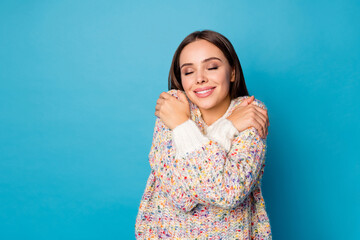 Poster - Photo of attractive overjoyed lady good mood straight hairdo hold hands hug shoulders enjoy joyful soft cloth warmth eyes closed wear casual sweater isolated blue color background