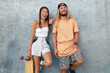 © puhhha - Couple With Skateboards Portrait. Happy Guy And Girl In Casual Outfit Against Concrete Wall At Skatepark. Urban Subculture And Skateboarding As Lifestyle Of Active People In City.