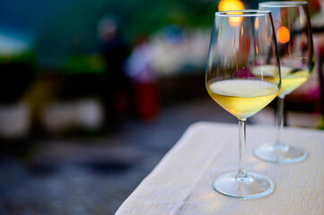 Two glasses of cold dry white wine served outdoor in cafe at night in Italy