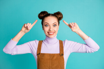 Photo of cute funny crazy glad lady overjoyed new hairdresser amazing coiffure index fingers direct two lovely buns wear violet sweater brown overall isolated vivid turquoise color background