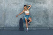 © puhhha - Skater Girl At Skatepark. Full-Length Portrait Of Female Hipster In Casual Outfit With Skateboard Against Concrete Wall At Skate Park. Urban Subculture Style And Summer Sport In City. Active Lifestyle