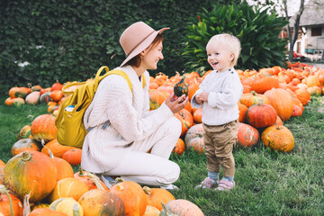 happy mother and child at pumpkin patch outdoors.