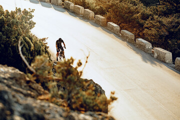 Wall Mural - Professional cyclist on a mountain road at sunrise