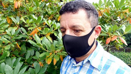 image depicting the face of a man with a black protective anti-contagion mask