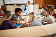 © luckybusiness - Group of students consults in amphitheater