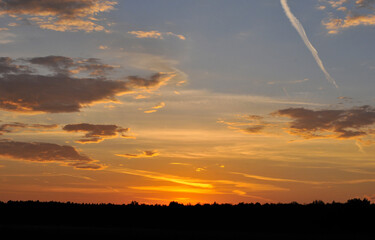 The sun rises. Clouds are highlighted