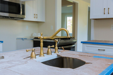 Wall Mural - Plumber installation of the faucet of a sink in kitchen