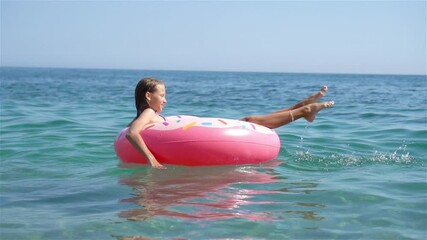 Wall Mural - Adorable girl on inflatable air mattress in the sea