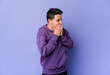 © Asier - Young caucasian man isolated on purple background laughing about something, covering mouth with hands.