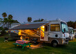 Rv camping in a Rv resort under the evening sky with lights on the coach