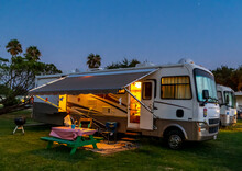 Rv Camping In A Rv Resort Under The Evening Sky With Lights On The Coach