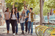 © SuperStock - Smiling coworkers walking on sidewalk during lunch break on street