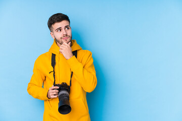 Young caucasian photographer man isolated looking sideways with doubtful and skeptical expression.