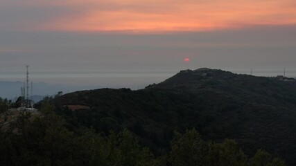 Wall Mural - Sunset views in Santa Cruz mountains; Red setting sun barely visible through the smoke cloud from the nearby burning wildfires; South San Francisco Bay Area, California