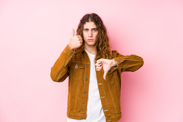 Wall Mural - Young long hair man posing isolated showing thumbs up and thumbs down, difficult choose concept