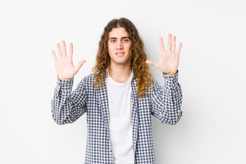 Wall Mural - Young long hair man posing isolated showing number ten with hands.