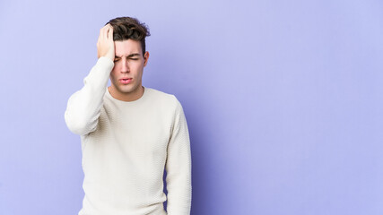 Wall Mural - Young caucasian man isolated on purple background tired and very sleepy keeping hand on head.