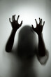 Ghost concept shadow of a woman behind the matte glass blurry hand and body soft focus