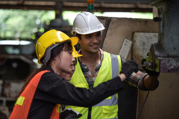 Group of technician man and industrial women worker with hard hat or helmet and vest jacket working electronic machinery and mechanical engineering in Factory of manufacturing place