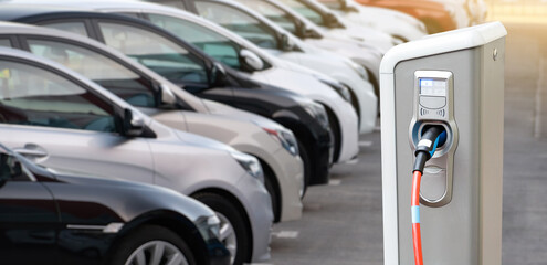 Sticker - Close-up of a electric charging station on the background of cars