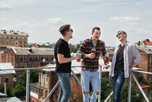 Happy Smiling Male Friends Drinking Beer And Clinking Glasses At Bar Or Pub On Rooftop, Copy Space. Friendship And Celebration Concept