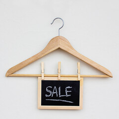 empty clothes hanger on light background with sale sign