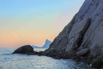 Wall Mural - rocks on the seashore at sunset