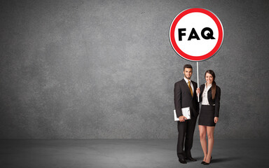 Young business person holdig traffic sign with FAQ abbreviation, technology solution concept