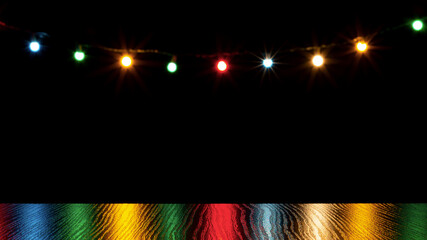 Colorful christmas lights reflection on wooden table and bokeh of holiday garland on background.