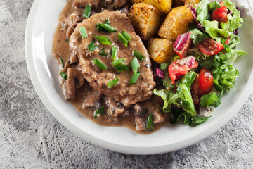 Canvas Print - Pork loin chop with mushroom sauce and baked potatoes