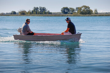 Wall Mural - Two men in a small boat.