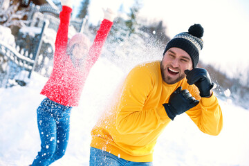 Poster - Happy couple playing snowballs outdoors. Winter vacation