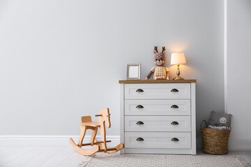 Poster - modern white chest of drawers near light wall in child room, space for text. interior design