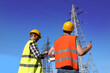 © New Africa - Professional electricians in uniforms near high voltage towers