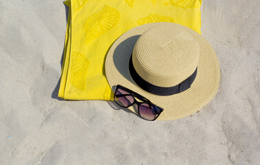 sunglasses,towel and hat on the sand