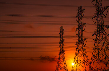 High voltage electric pole and transmission lines in the evening. Electricity pylons at sunset. Power and energy. Energy conservation. High voltage grid tower with wire cable at distribution station.