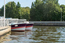 Two Boats Are Moored At The Pier Of The River
