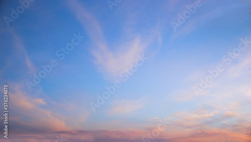Fotografía blue sky and fluffy pink clouds at sunset, horizontal format