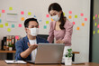 © 220 Selfmade studio - Startup of Business man and woman wearing face mask meeting and working together for discussion and brainstroming to get ideas or marketing solution due virus pandemic