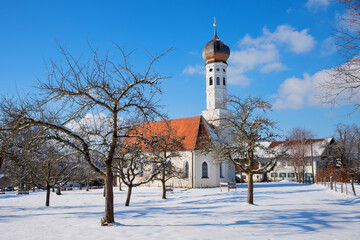 Wall Mural - typical bavarian church in winter landscape, bare-leaved apple trees