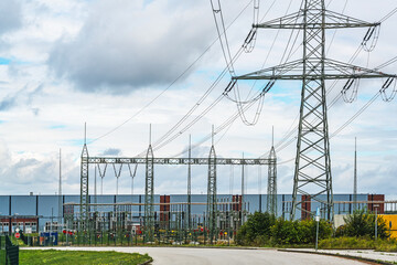 Electricity pylons in the transformer substation at the interim storage facility of the former nuclear power plant in Lubmin near Greifswald in Germany, cloudy sky with copy space