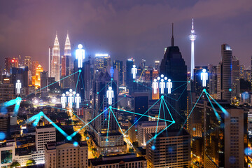 Glowing Social media icons on night panoramic city view of Kuala Lumpur, Malaysia, Asia. The concept of networking and connections between people and businesses in KL. Double exposure.